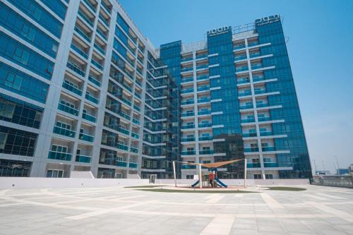 a large building with a playground in front of it at Jood Hotel Apartments in Dubai