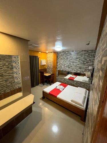 a bedroom with two beds and a table in it at Queen Maricel Inn in Virac