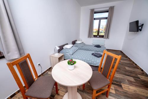 a room with a bed and a table and chairs at Kammerer Vendégház in Kastélyosdombó