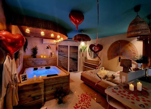 a room with a jacuzzi tub in a room with balloons at Les Spas de la Mer, Appart&Spa Aloha, 100m de la plage, Plein cœur du Grau in Le Grau-du-Roi