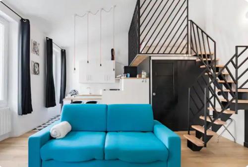 - un canapé bleu dans le salon avec un escalier dans l'établissement Maison Pépouze, à Marseille