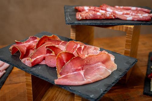 a slab of bacon on a black plate on a table at Relais Villa Al Vento in Incisa in Valdarno