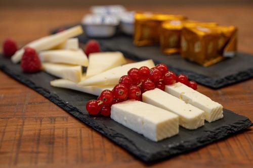 a plate of cheese and berries on a table at Relais Villa Al Vento in Incisa in Valdarno