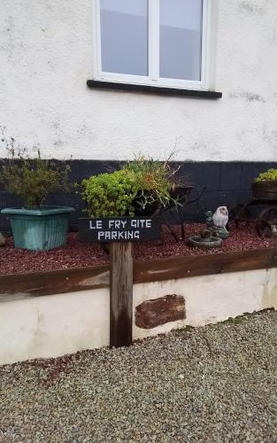 a sign that says he few elite gardening in front of a house at Le Fry Holiday Gite in Lithaire
