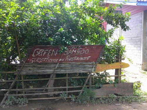 a wooden bench sitting in front of a tree at Loy Guesthouse and Restaurant Sunset Side in Don Det