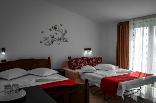 a bedroom with two beds and a table and a window at Roman Costinesti in Costinesti