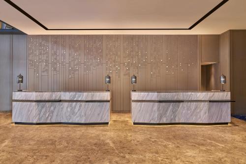 a lobby with a row of marble reception desks at Marriott Executive Apartments Penang in George Town