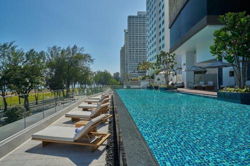 a swimming pool with lounge chairs next to a building at Marriott Executive Apartments Penang in George Town