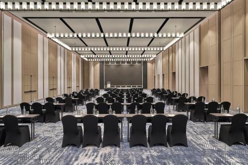 a conference room with tables and chairs and a projection screen at Marriott Executive Apartments Penang in George Town