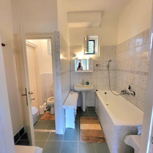 a bathroom with a tub and a sink and a toilet at Fenyves Villa in Balatonakarattya