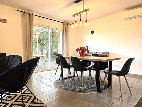 une salle à manger avec une table et des chaises dans l'établissement Le Clos Andrée - Charmante maison 8 personnes - 5 lits - Climatisation réversible - Parking 3 véhicules - Garage - Zone Nord Montauban - Terrasse et jardin, à Montauban