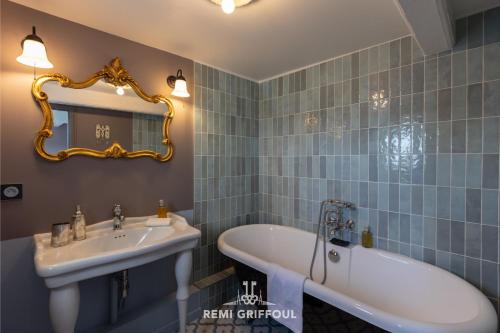 une salle de bain avec une baignoire, un lavabo et un miroir dans l'établissement Dolphin View - 2nd floor - Beautiful flat with view of the port, à Honfleur