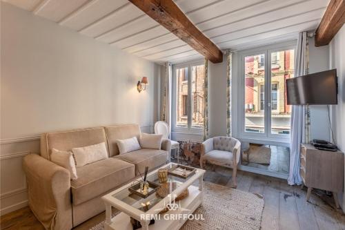un salon avec un canapé et une table dans l'établissement Dolphin view - 1st floor - Charming comfortable flat on the port, à Honfleur