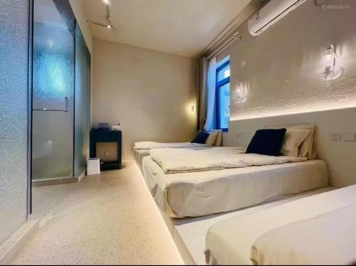 a room with three beds and a window at 北京怀柔方糖民宿 in Sanduhe