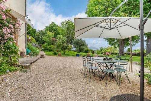 - une table et des chaises avec un parasol dans la cour dans l'établissement The terasse - Sublime residence with swimming pool, à Collonges-au-Mont-dʼOr