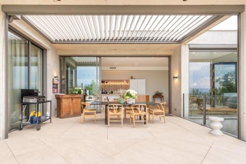 une cuisine et une salle à manger avec une table et des chaises dans l'établissement Futuriste - Exceptional residence with panoramic view, à Saint-Didier-au-Mont-dʼOr