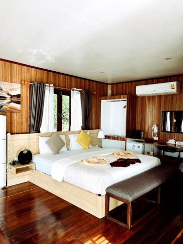 a bedroom with a large white bed and a desk at A-Na-Lay Resort Koh Kood in Ko Kood