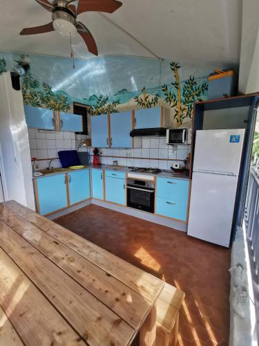 una cucina con un frigorifero bianco e un tavolo di legno di Trois mats a Saint-François
