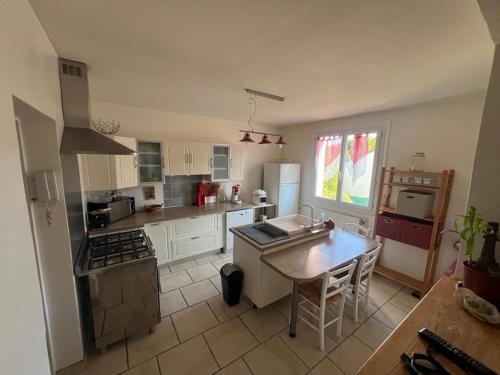 une cuisine avec des armoires blanches et une table à l'intérieur dans l'établissement Blé, à Viviers