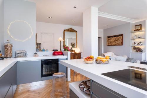 une cuisine avec un grand comptoir blanc et une chambre dans l'établissement Panorama - Magnificent flat with breathtaking view of Fourvière Basilica, à Lyon