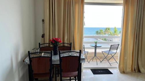 a dining room with a table and a view of the ocean at Beautiful Salalah Beach Apartments - 1 by Beautiful Salalah Tours in Salalah