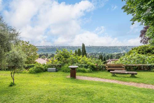 un parc avec un banc et un bain d'oiseaux dans l'établissement The terasse - Sublime residence with swimming pool, à Collonges-au-Mont-dʼOr
