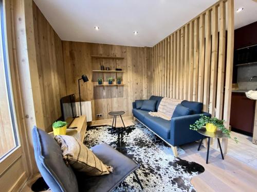 - un salon avec un canapé bleu et des murs en bois dans l'établissement Résidence Le Soleil Levant - Appartement Loulou - 4 personnes - Morzine centre MAE-4051, à Morzine