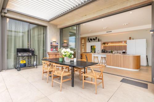 une cuisine et une salle à manger avec une table et des chaises dans l'établissement Futuriste - Exceptional residence with panoramic view, à Saint-Didier-au-Mont-dʼOr