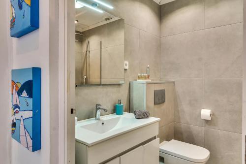 a bathroom with a sink and a toilet and a mirror at Bungalow Marquérite Moraira, 5 minutes from beach in Teulada