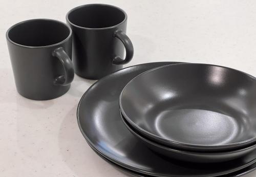 two black cups and a plate on a table at trias 102 in Tokyo