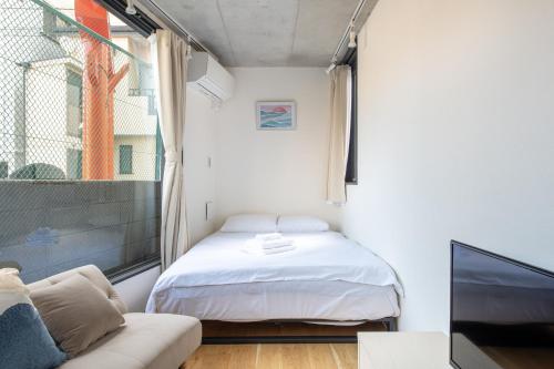 a small bedroom with a bed and a tv at trias 102 in Tokyo