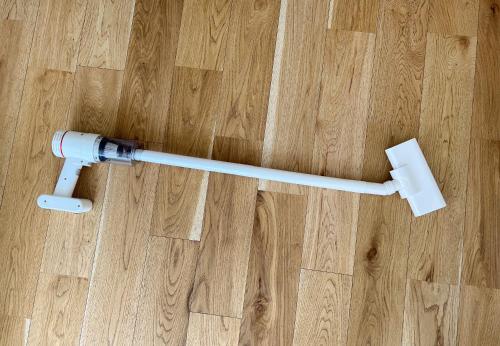 a white electric toothbrush laying on a wooden floor at trias 102 in Tokyo