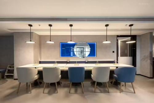 a dining room with a large white table and chairs at Atour Light Hotel Wuxi Nanchang Street Sanyang Plaza in Wuxi