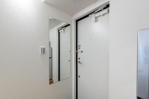 a bathroom with a mirror and a door at trias527 2-2 in Tokyo