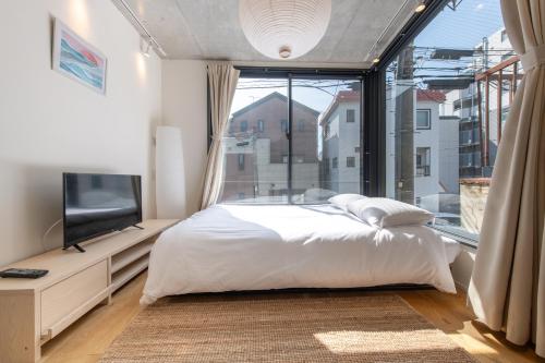 a bedroom with a bed and a large window at trias527 2-3 in Tokyo