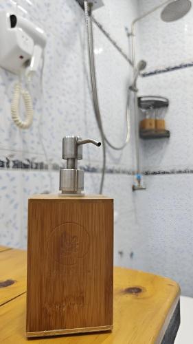 a soap dispenser sitting on top of a wooden table at Bougan Villea Retreat in Bodufolhudhoo