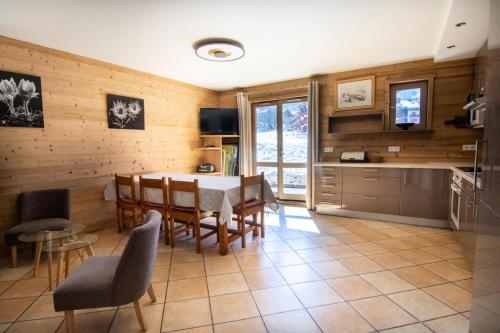 une cuisine et une salle à manger avec une table et des chaises dans l'établissement Résidence Altair - 4 pièces 8 personnes exposé sud MAE-1091, à Valloire