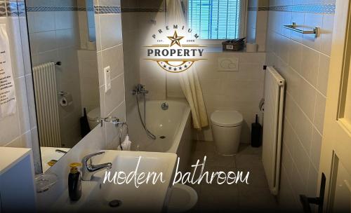 a bathroom with a sink and a bathtub and a sign at Magnificent SUNSTONE HOUSE, private parking, BBQ area, kids toys, near Como lake I Villa dei Leoni in Morbio Inferiore