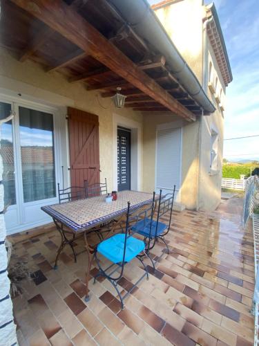 a patio with a table and chairs on a patio at Iris in Viviers