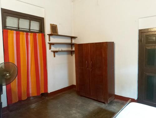 a room with a colorful curtain and a door at Olukaranda Walauwa in Kekirawa