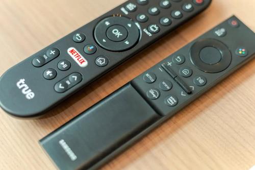 two remote controls sitting on top of a table at 曼谷豪华IDEORama9联排别墅 in Ban Na Song