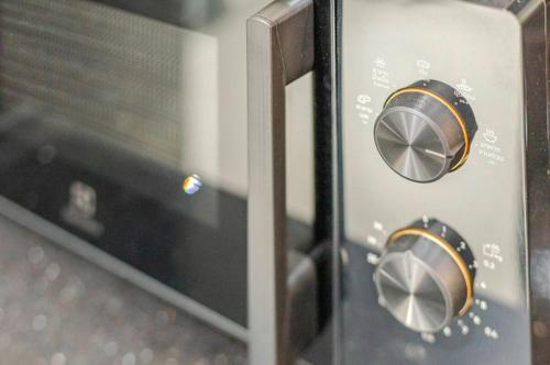a close up of a microwave oven with two knobs at 曼谷豪华IDEORama9联排别墅 in Ban Na Song