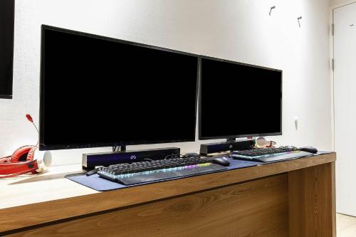 a desk with two computer monitors and a keyboard at Aank Hotel Incheon Bupyeong in Incheon