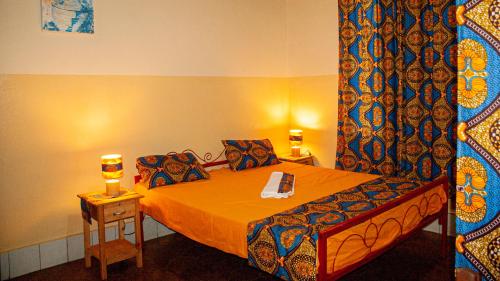 a bedroom with a bed with a curtain and a table at Maison d'Accueil - Fondation San Filippo Neri in Bujumbura