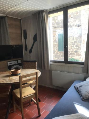 une chambre avec une table et une cuisine avec un lit dans l'établissement La Pierre de Lave appartement La Placette, à Agde