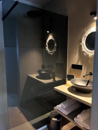 a bathroom with two sinks and two mirrors at B&B Leonie in Alveringem