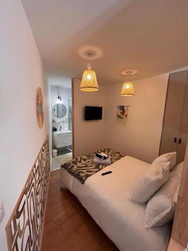 - une chambre avec un grand lit et deux lumières dans l'établissement Elégant petit appartement sete, à Sète