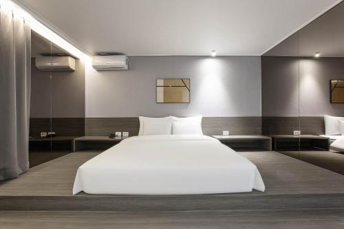 a bedroom with a large white bed and a couch at Aank Hotel Incheon Bupyeong in Incheon