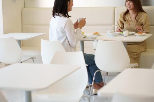 two women sitting at a table eating food at Hotel Vista Sapporo Nakajima Koen in Sapporo