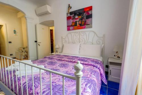 a bedroom with a bed with a purple comforter at White Lerici in Lerici